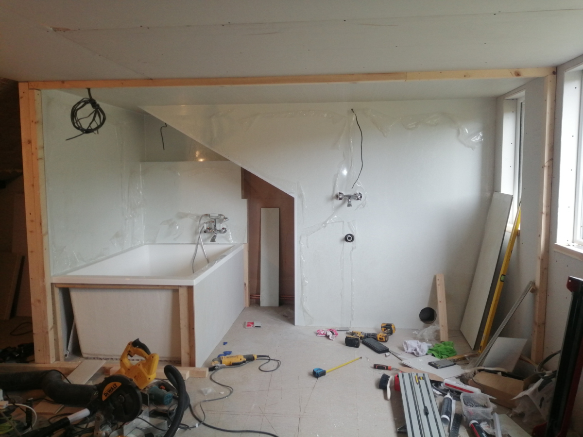 Bathroom view with plastic panelling, giant bath installed, no stud wall yet