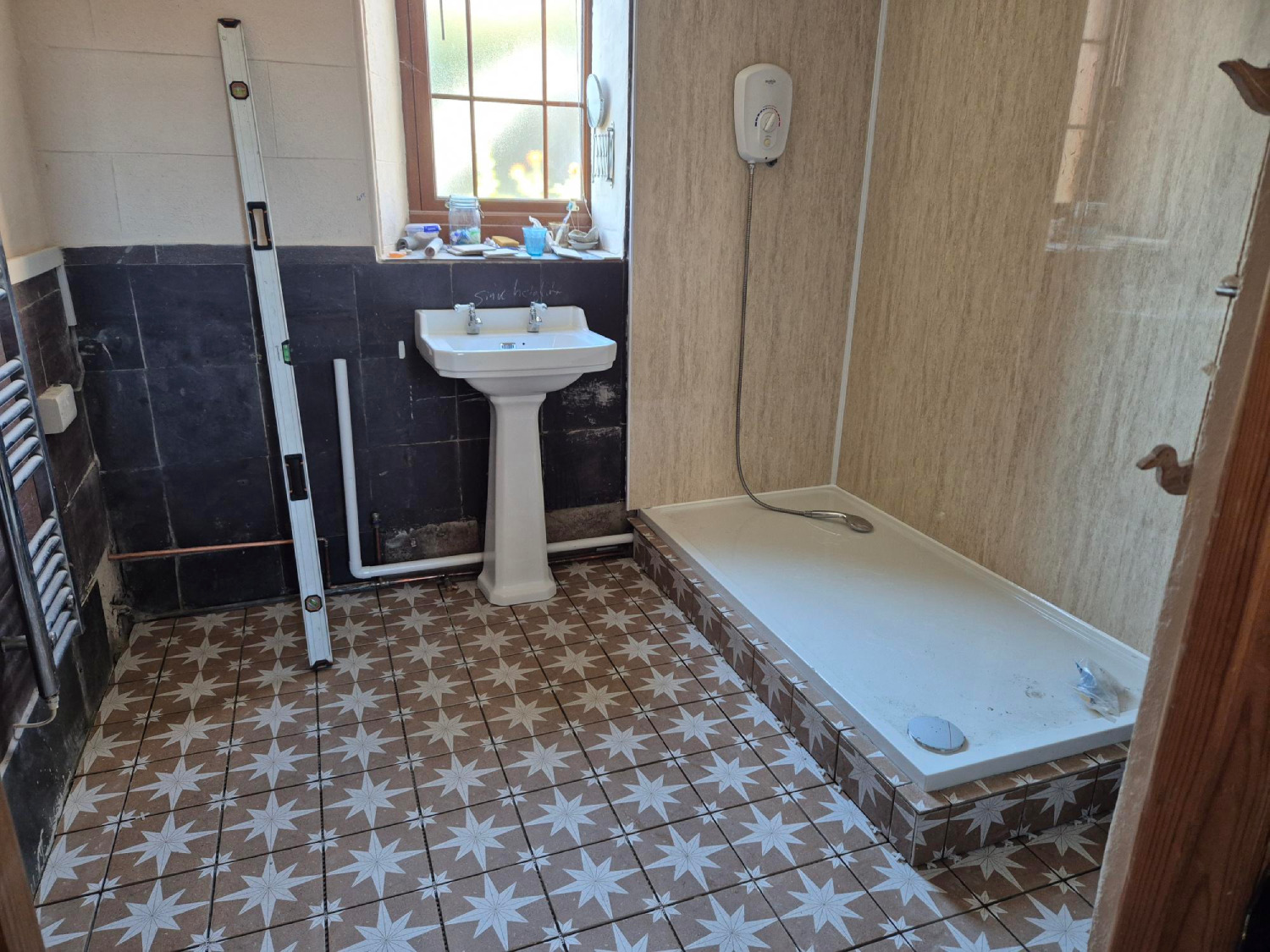 Chapel bathroom walk-in shower installed, wall panels up, floor tiled and sink installed