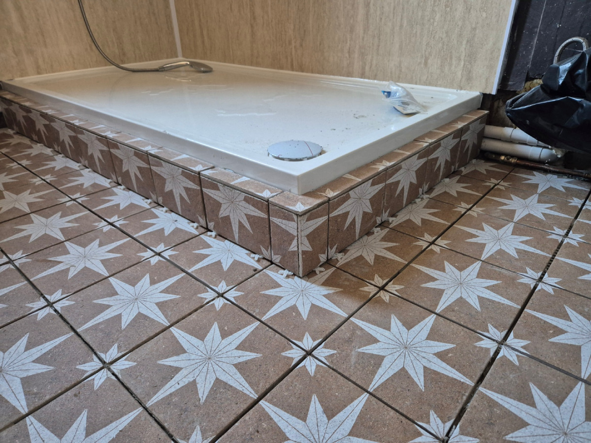 Close-up of the Aztec-style tile pattern around the shower base