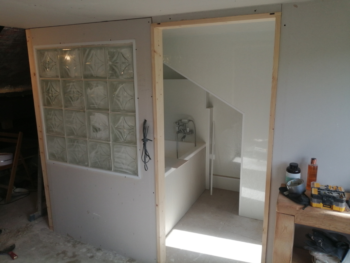 Looking into bathroom through the completed glass block wall with sliding door