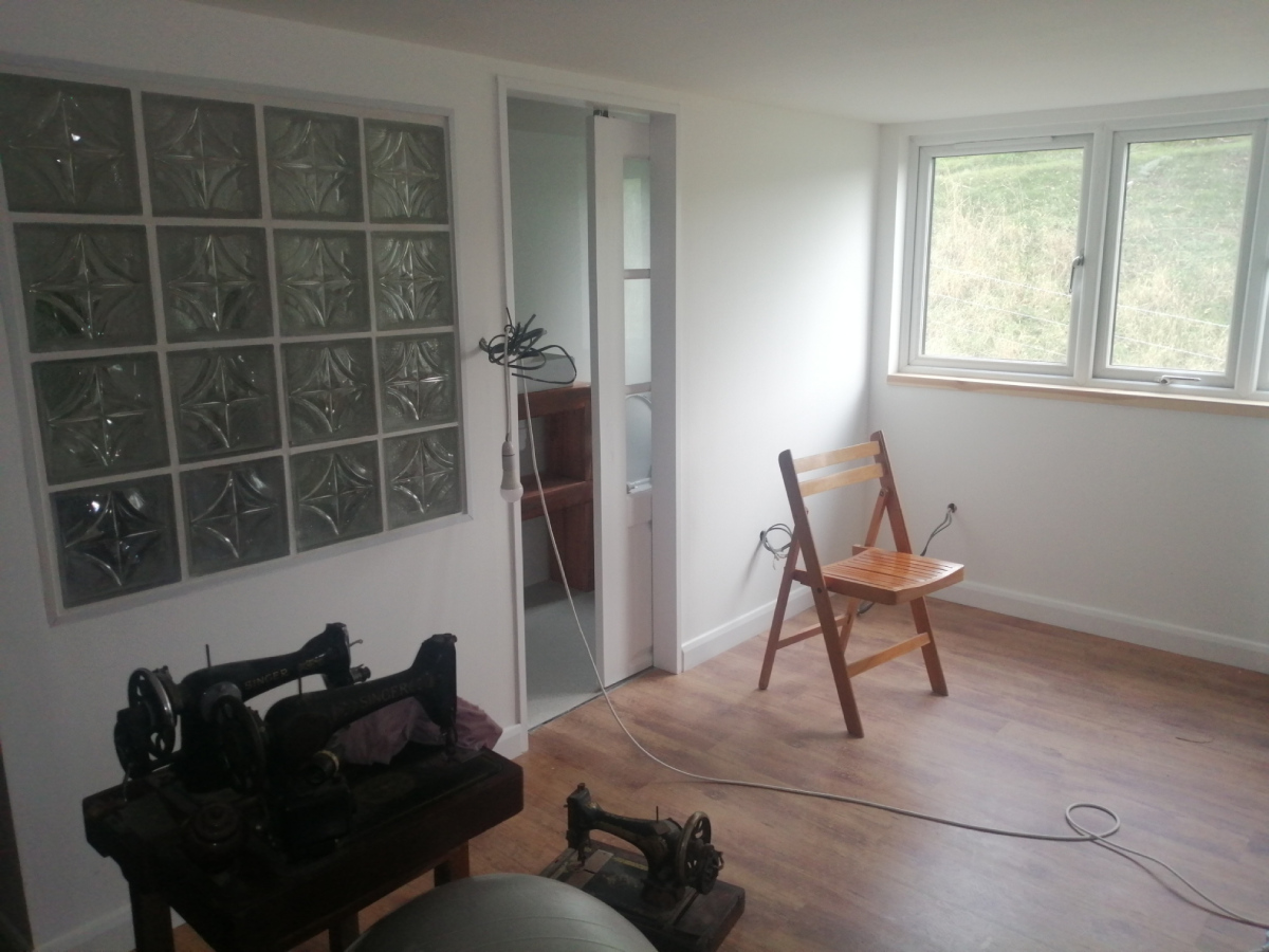 Complete bathroom from the dormer room showing glass wall, ceiling and laminated floor